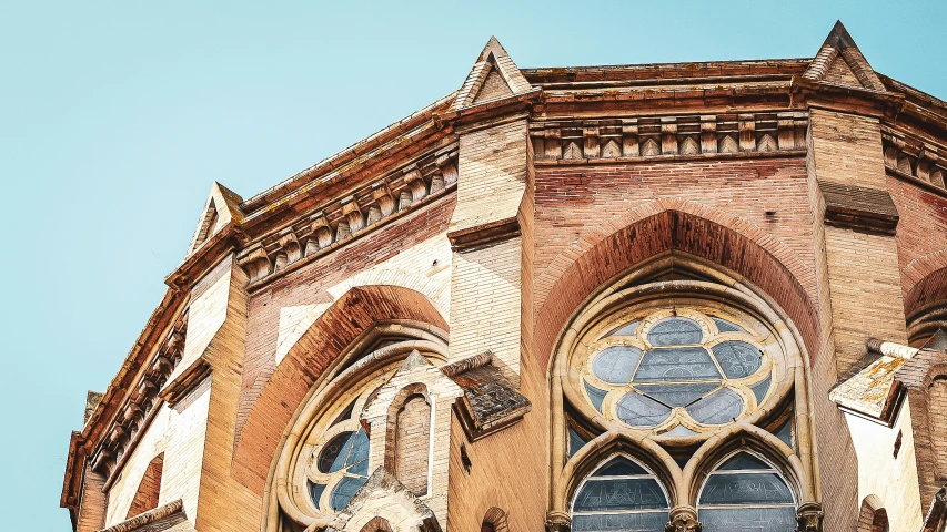 an old church has very large windows and a weathervane