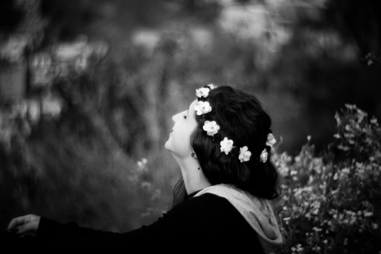 a person with flowers in their hair standing next to trees