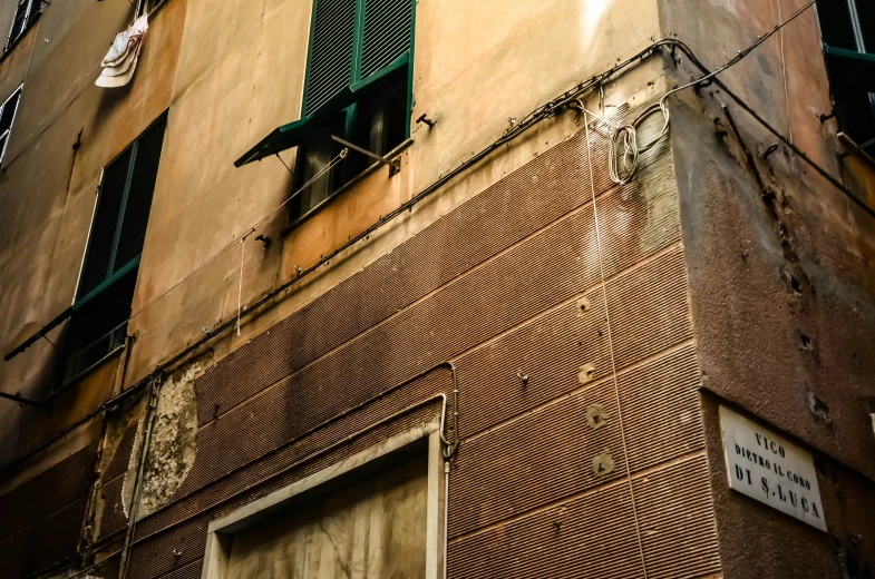 an old building with a window and green shutters