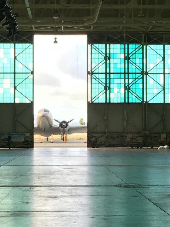 an airplane sits parked in a hangar while its lights are on