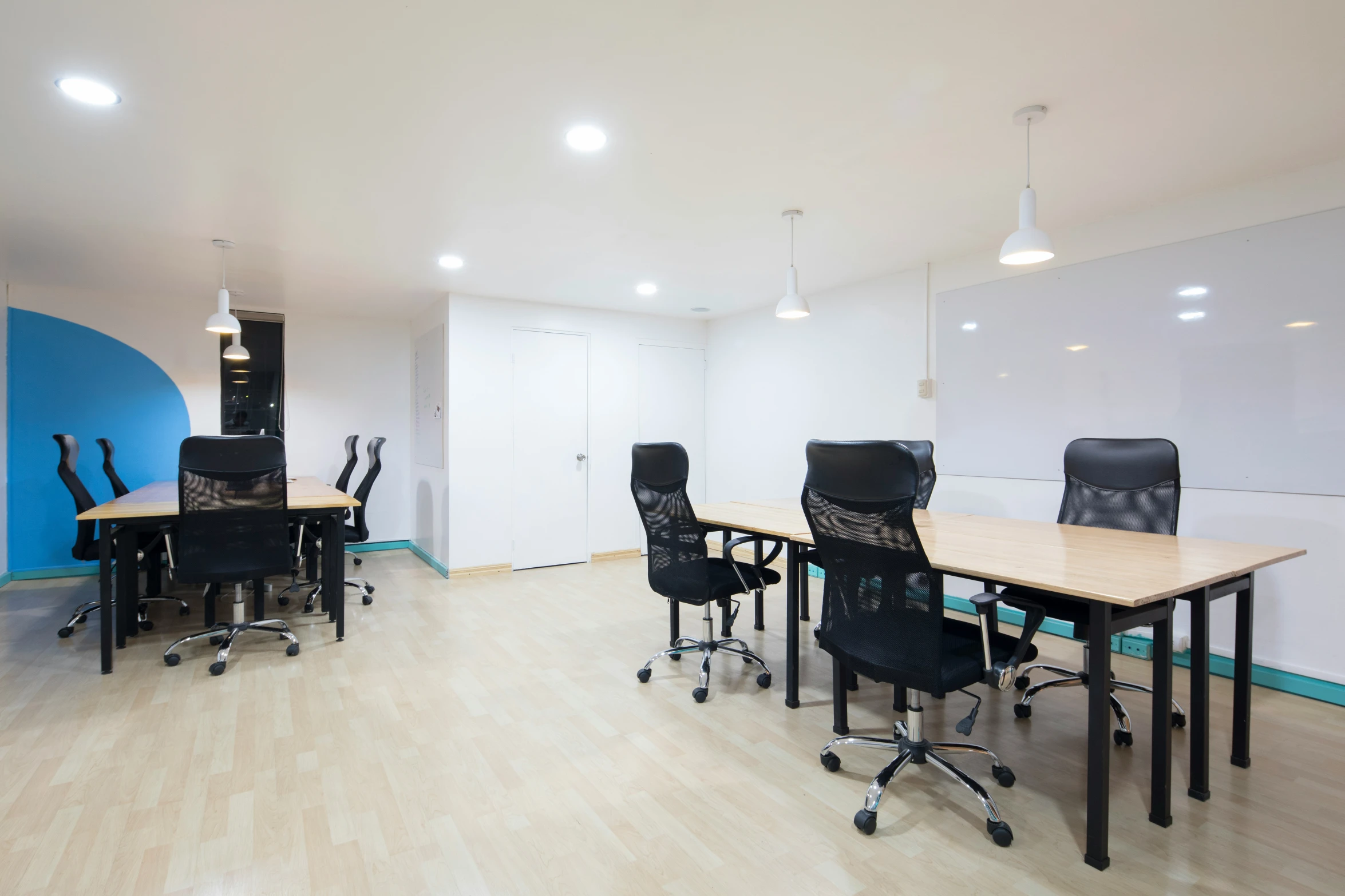 an empty office with black chairs and a long table