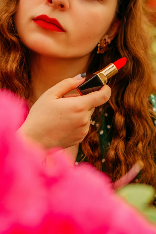 a close up of a person putting lipstick on