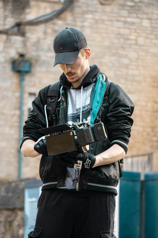 a young man in his back wearing a baseball cap and holding out his phone