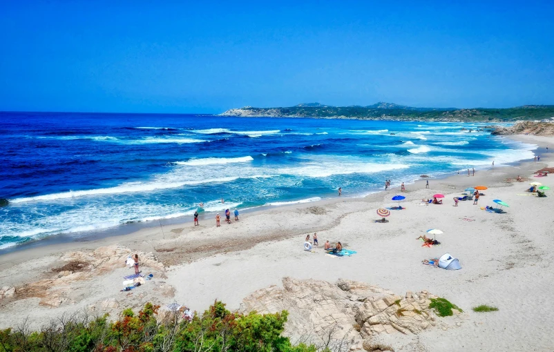 a beach with lots of people on the sand