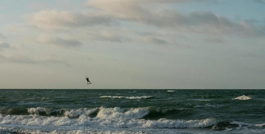 the person is flying a kite on the ocean