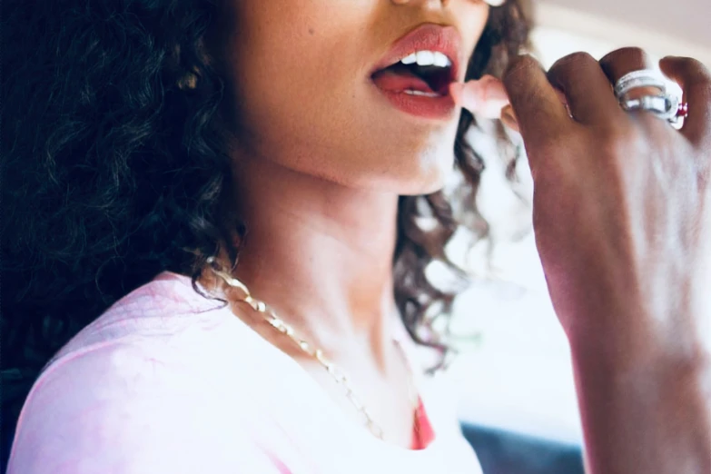 an african american woman holding up a ring in her right hand