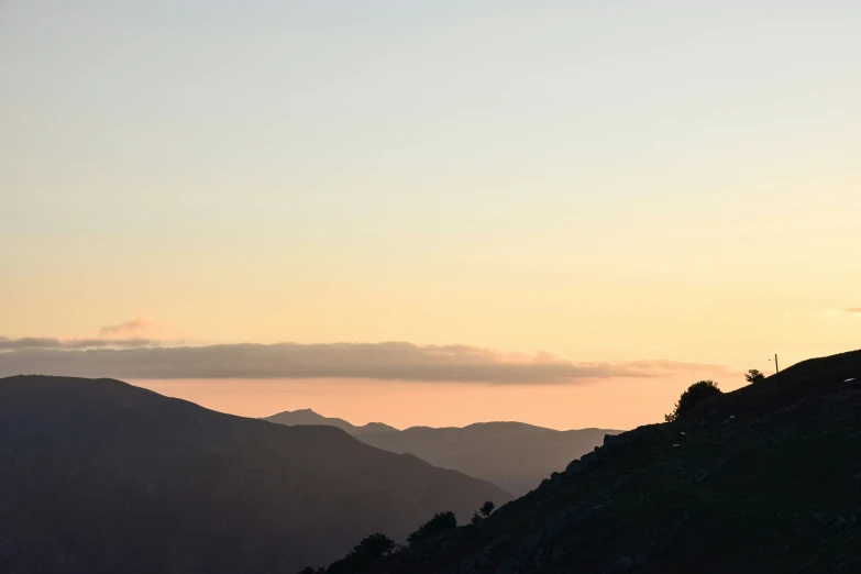 a person walking up the side of a mountain at sunset