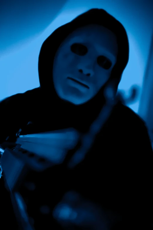 a man with face makeup, black hoodie and a tooth brush