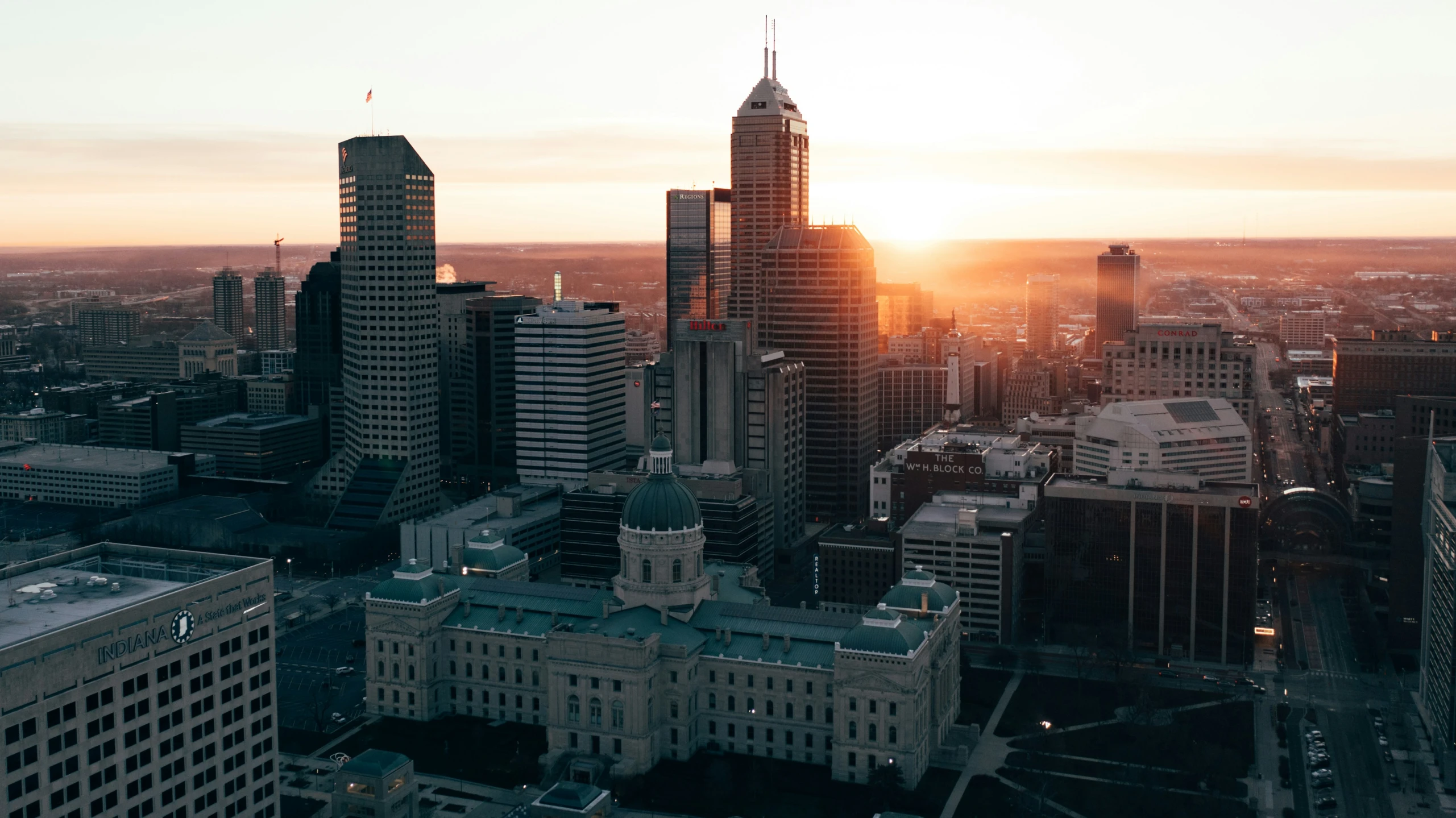 the sun sets over a city and it is almost visible