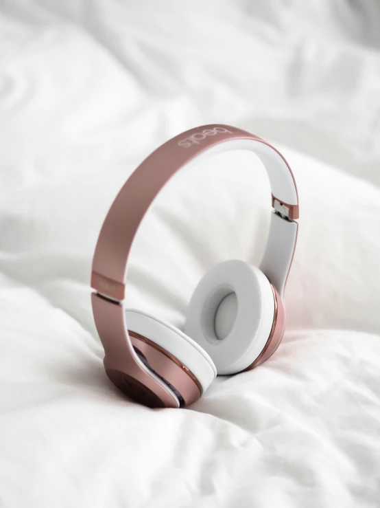 an electric headphones laying on a white sheet