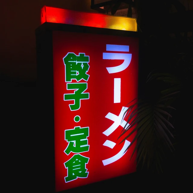 asian sign with foreign text on it lit up at night