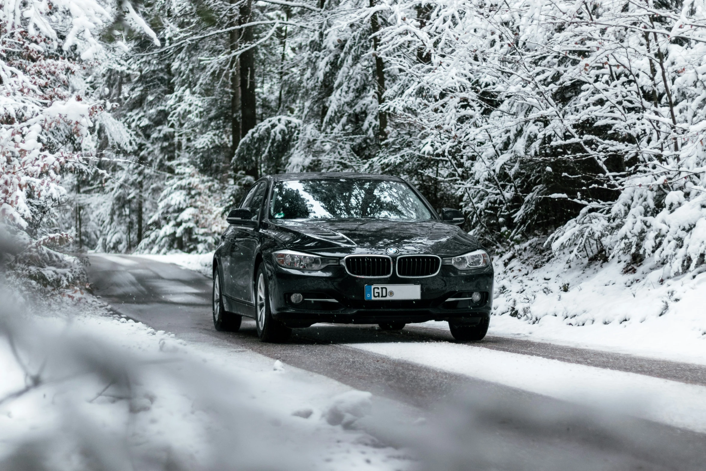 a car driving down a snow covered road