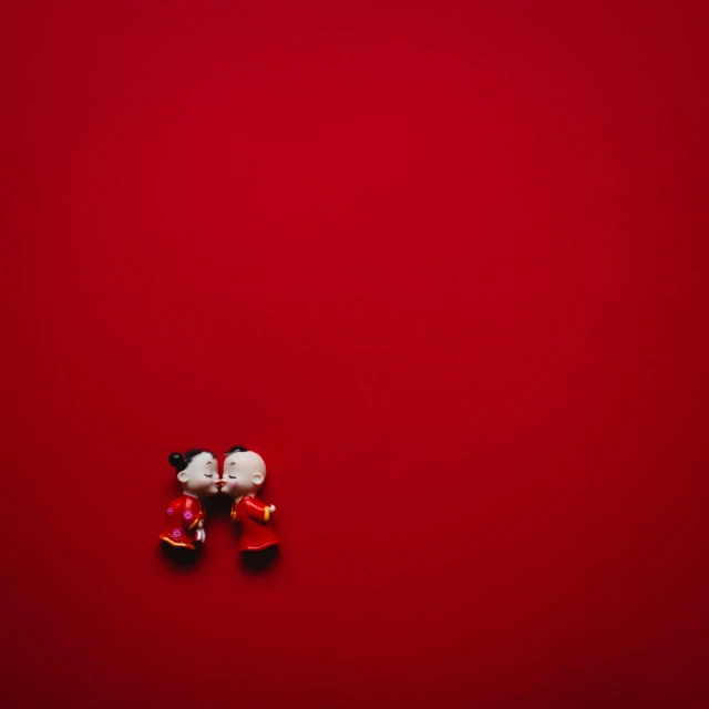 two red shoes laying on top of a red surface