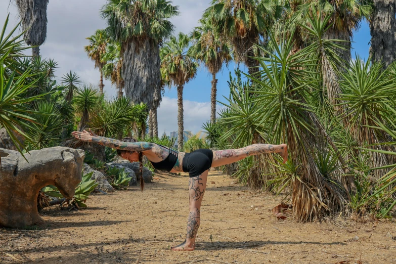 a woman practicing a yoga pose in a tropical setting