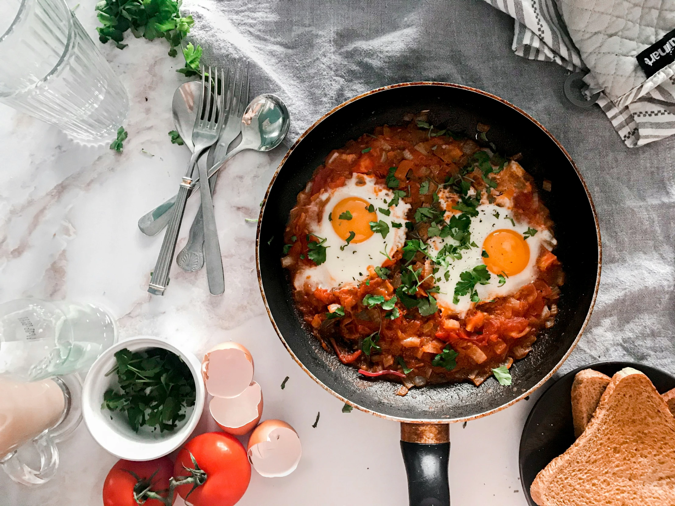 two eggs sit in an iron set and next to toast