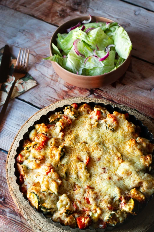 a baked dinner with vegetable pie next to a salad