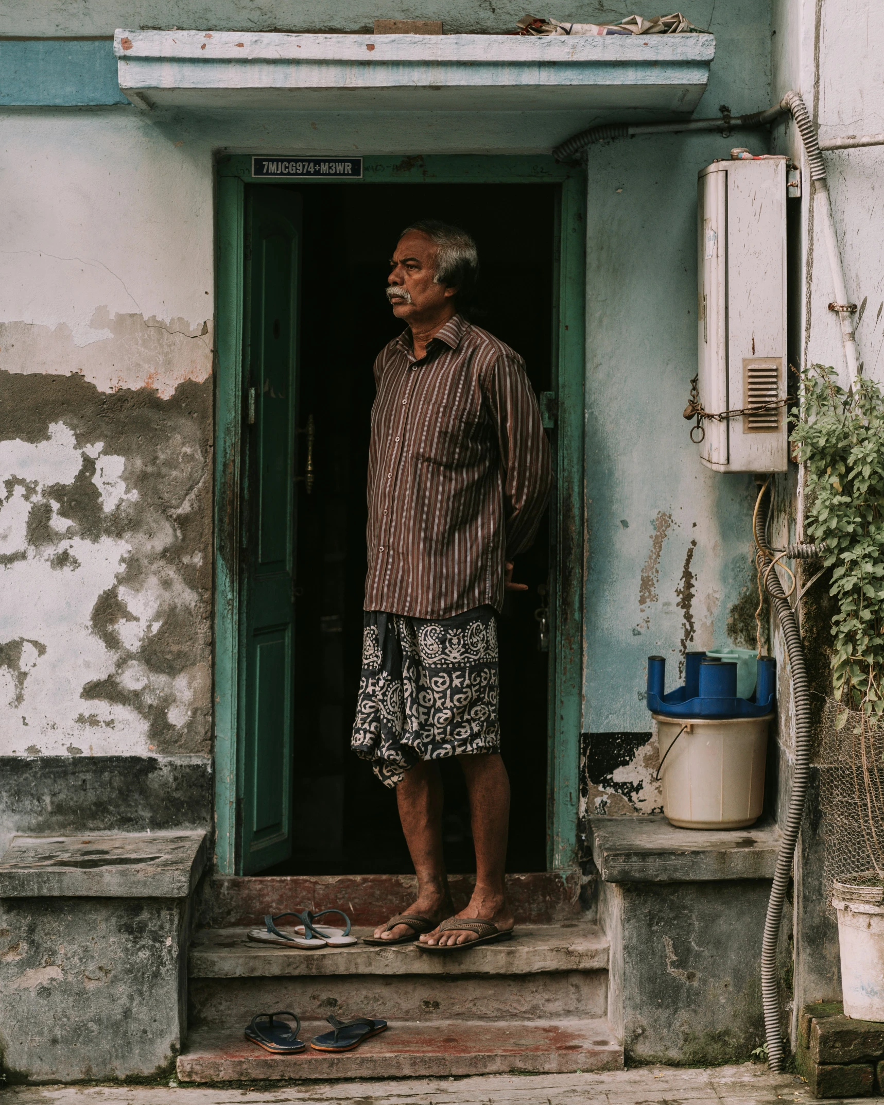 a man is standing in the doorway with his feet up