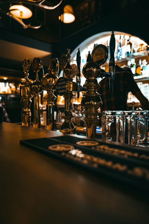 some gold clocks and glassware on a counter