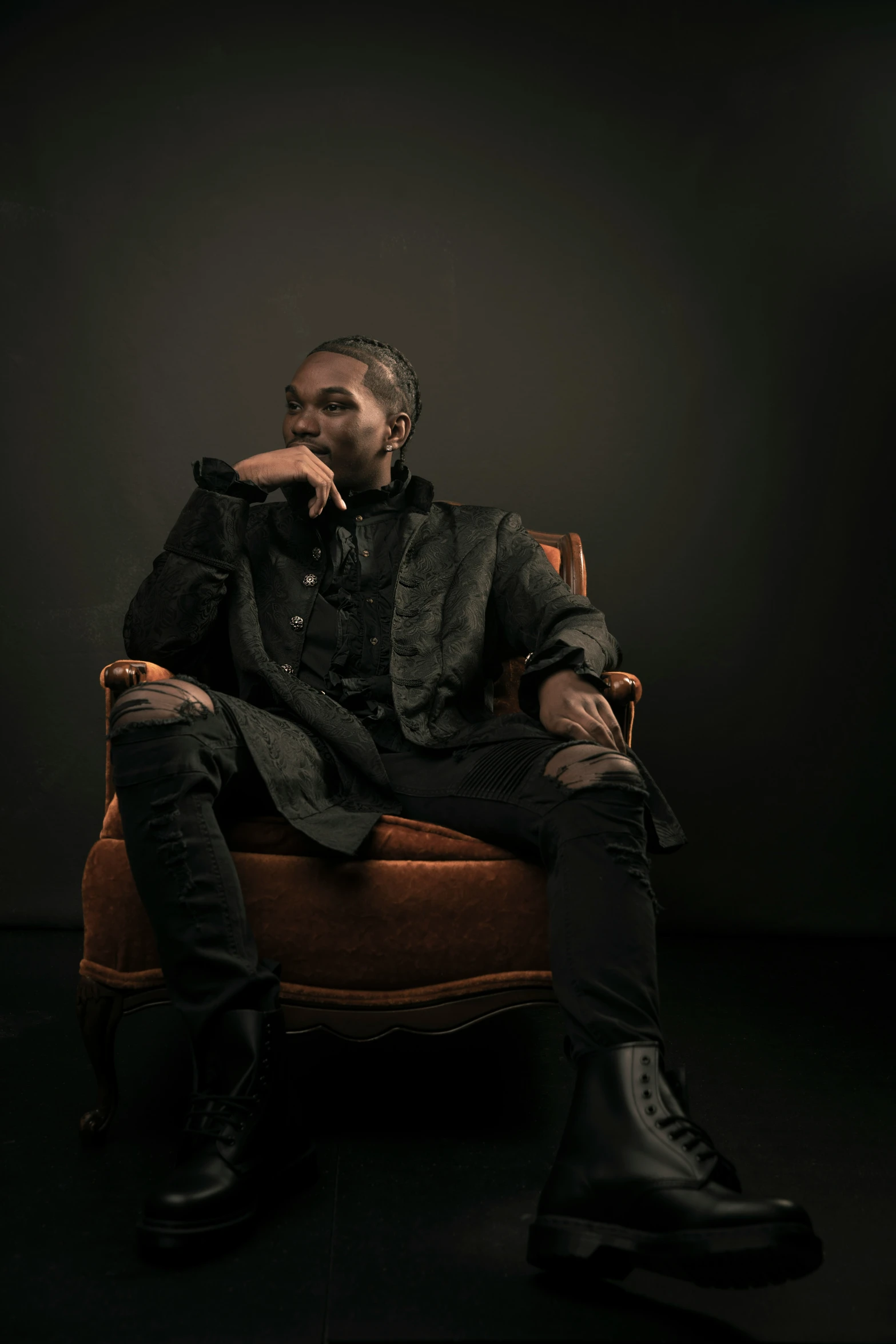 a man is posing for the camera while sitting on a brown chair