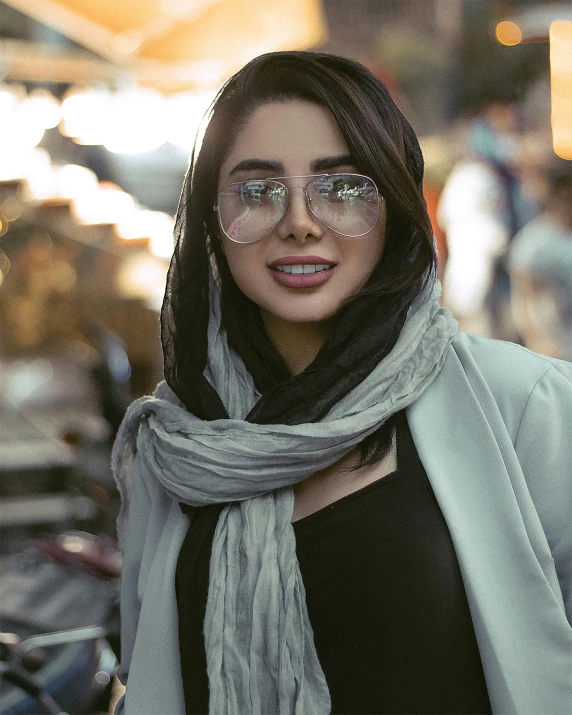 woman posing for the camera, with her coat and sunglasses closed