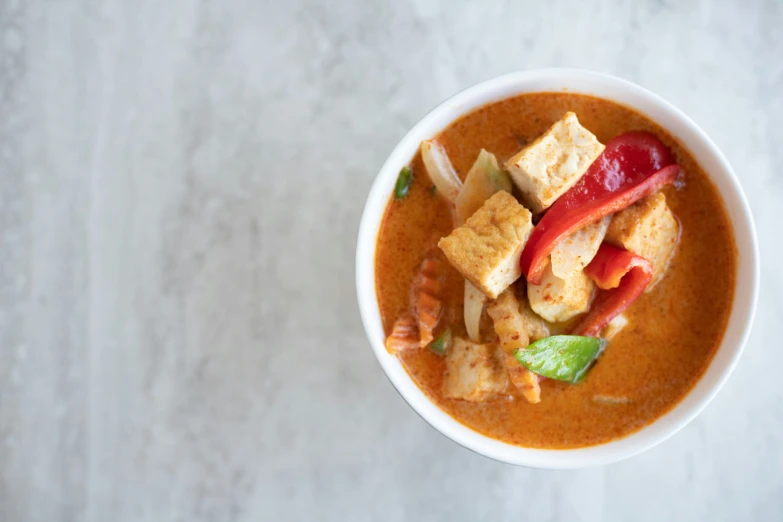 the bowl of soup is full of croutons, cheese, and red chili