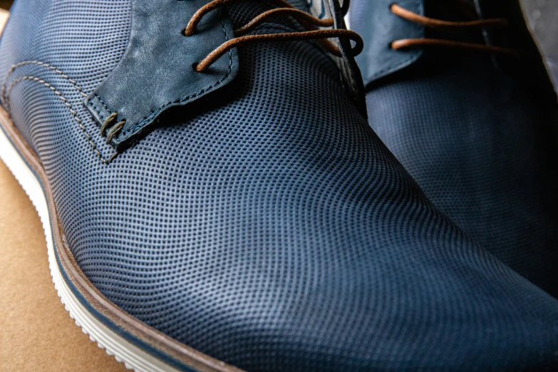 the shoe of a man's feet with a blue canvas cloth covered shoe lace