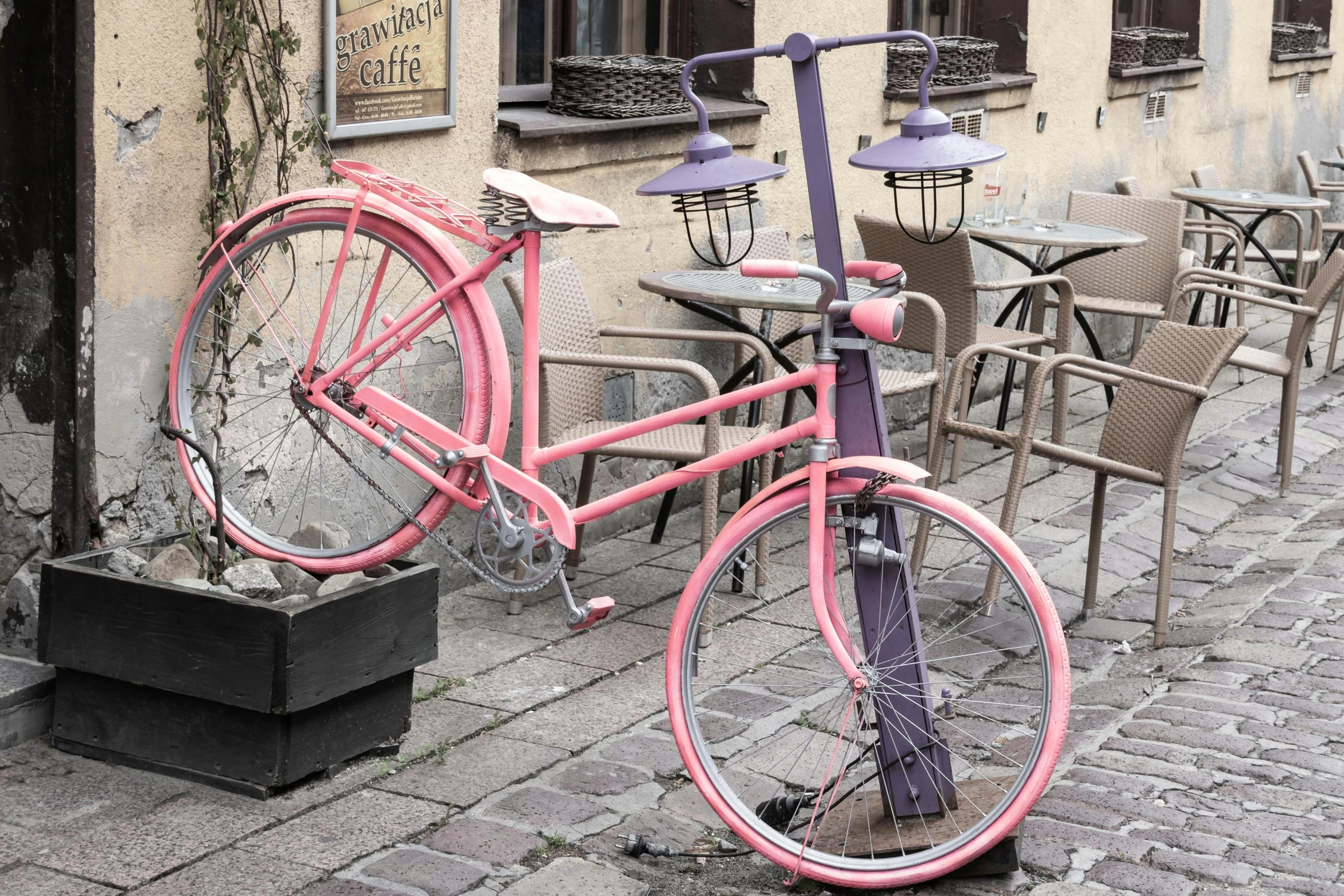 a pink bicycle parked in front of a building