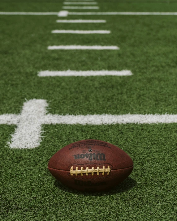 an american football on a football field in front of a line