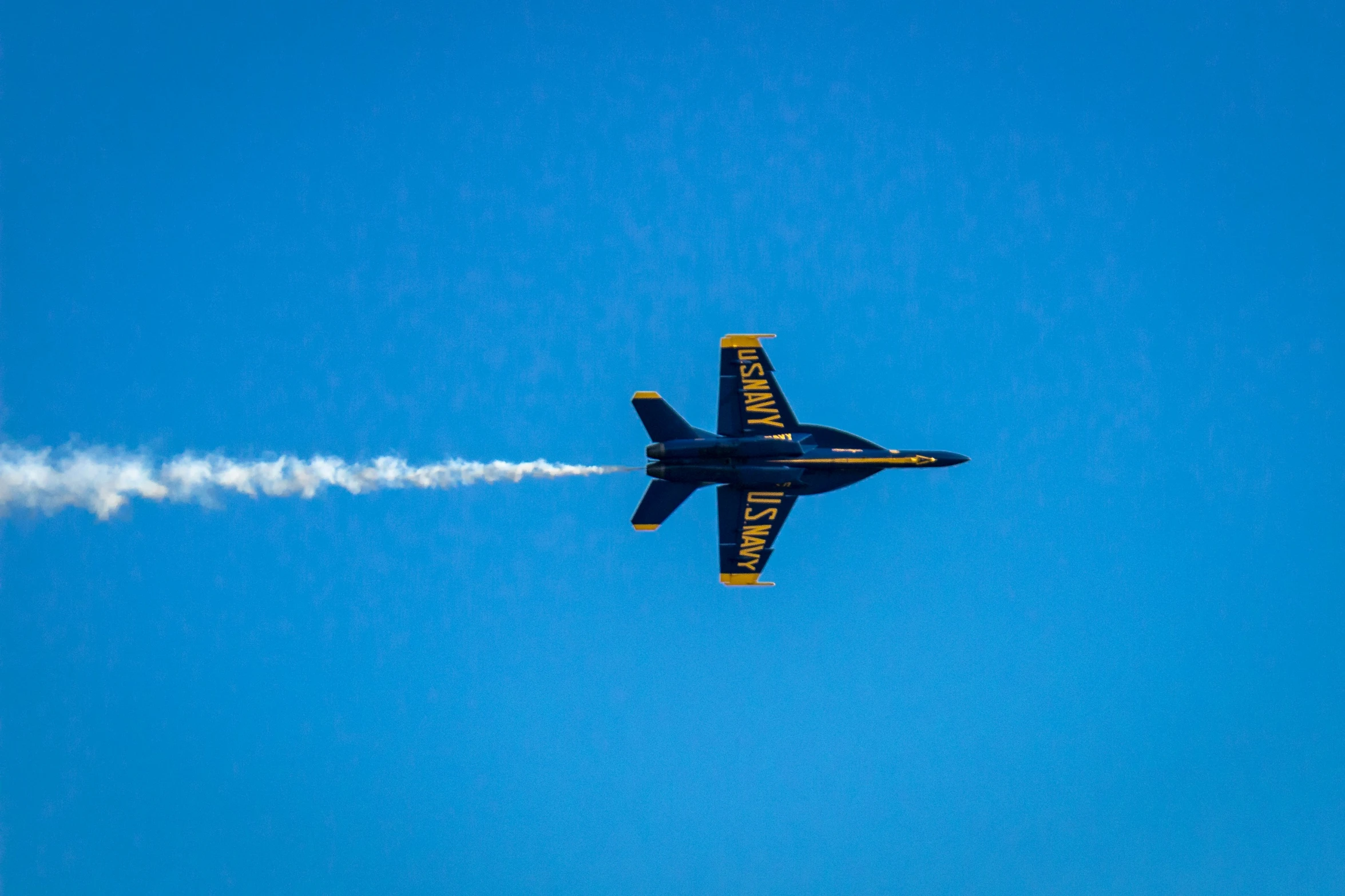 an airplane flying through the air leaving a trail of smoke