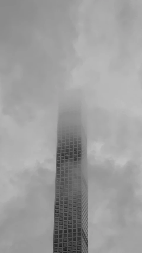 black and white po of building surrounded by fog