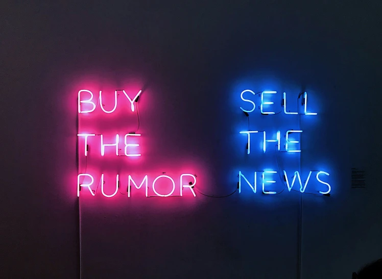 two neon signs that are hanging on the side of a wall