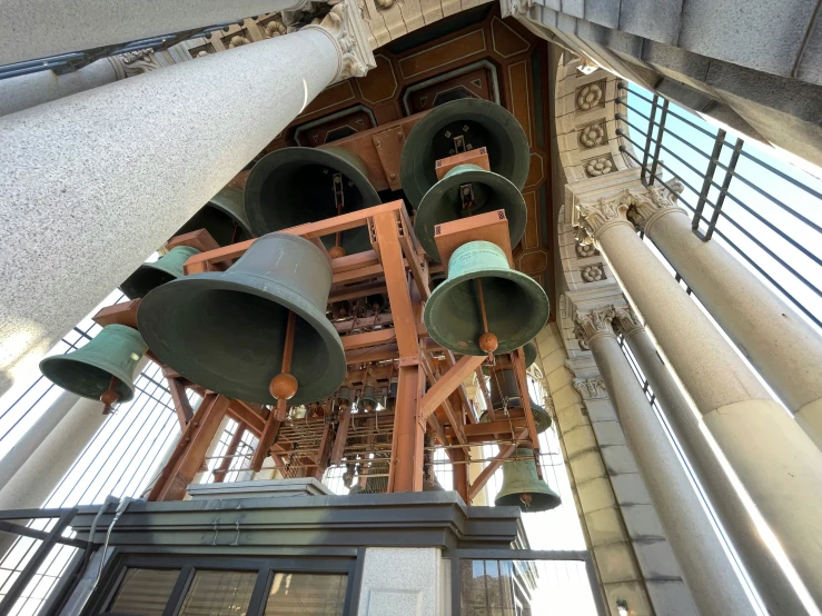 large bells are mounted to the ceiling inside of the building