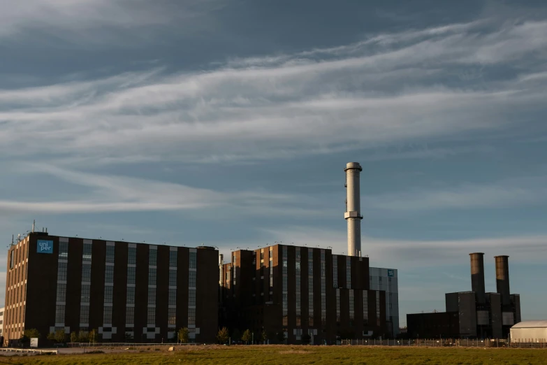 a large factory with smoke stacks in the foreground