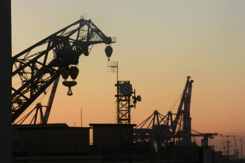 a crane stands in the middle of a factory field