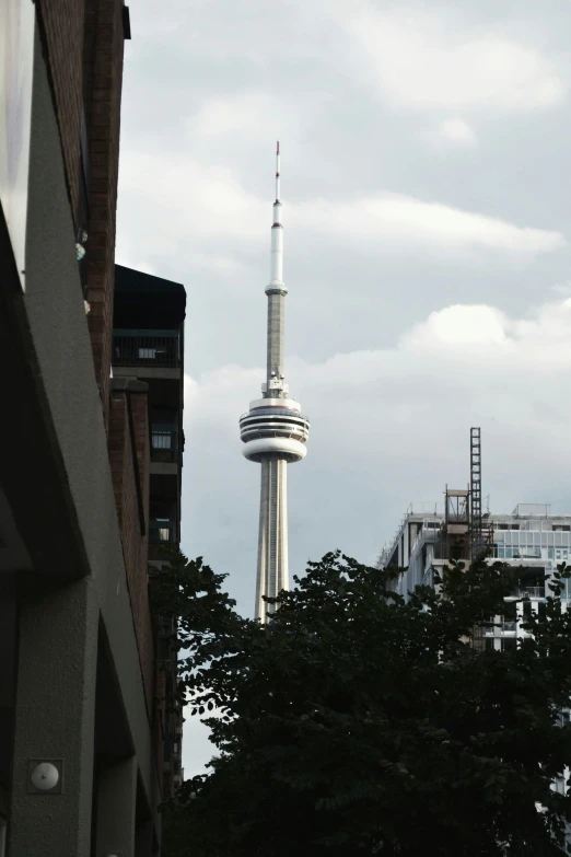 a tall building sits in the distance behind a group of buildings