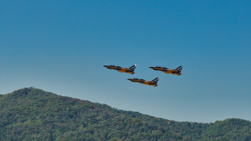 a group of jets flying in formation above a mountainous area