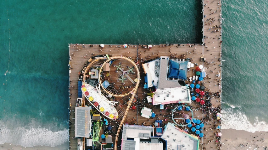 a fair is sitting by the ocean while people ride on it