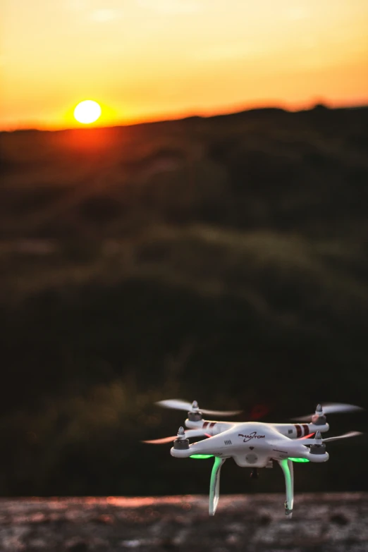 a small white and red toy aircraft flying at sunset