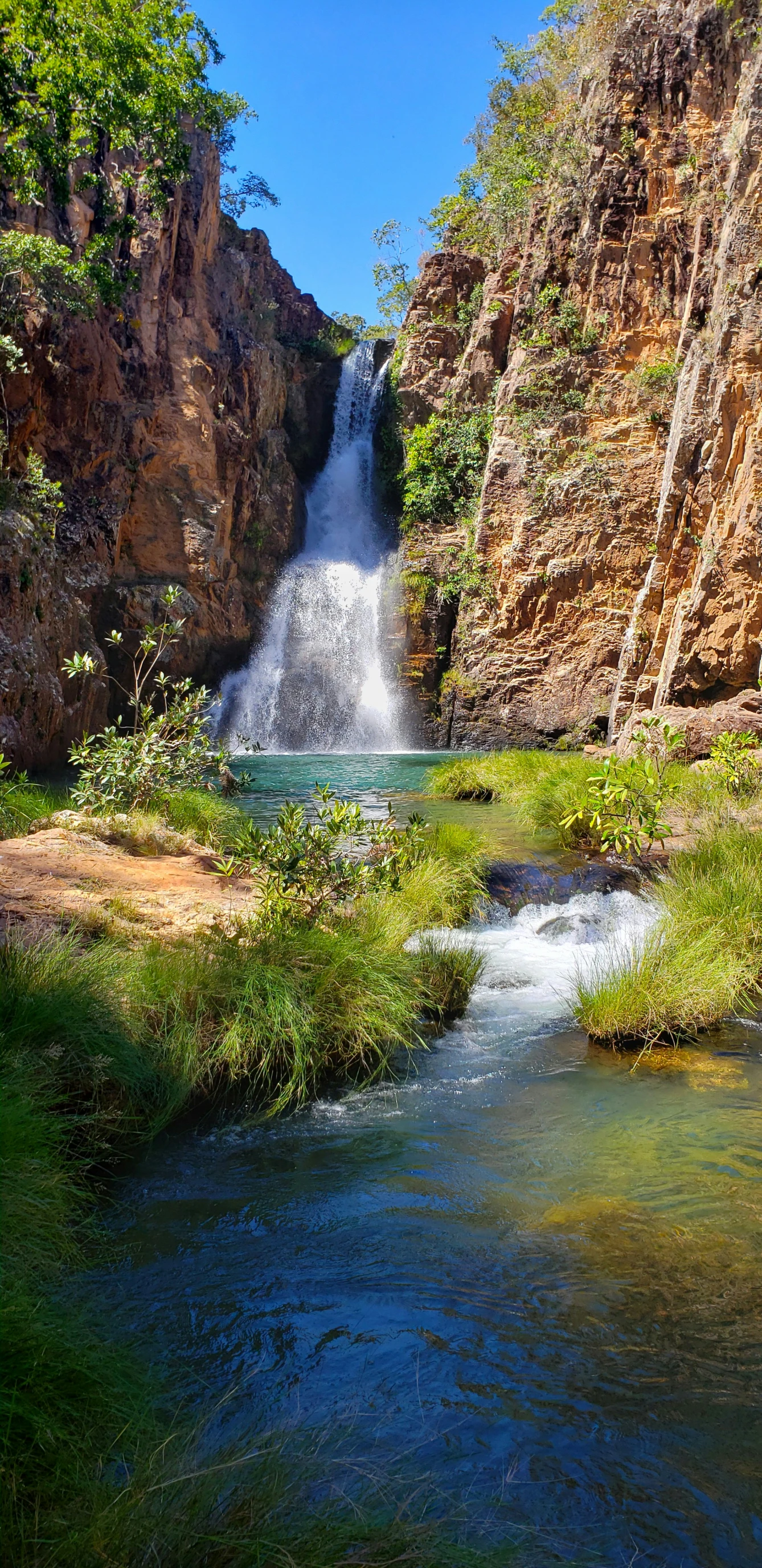 an artificial waterfall with people on the bank