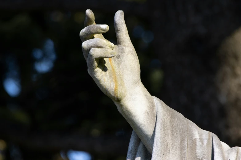 a statue is holding a lit candle in one hand