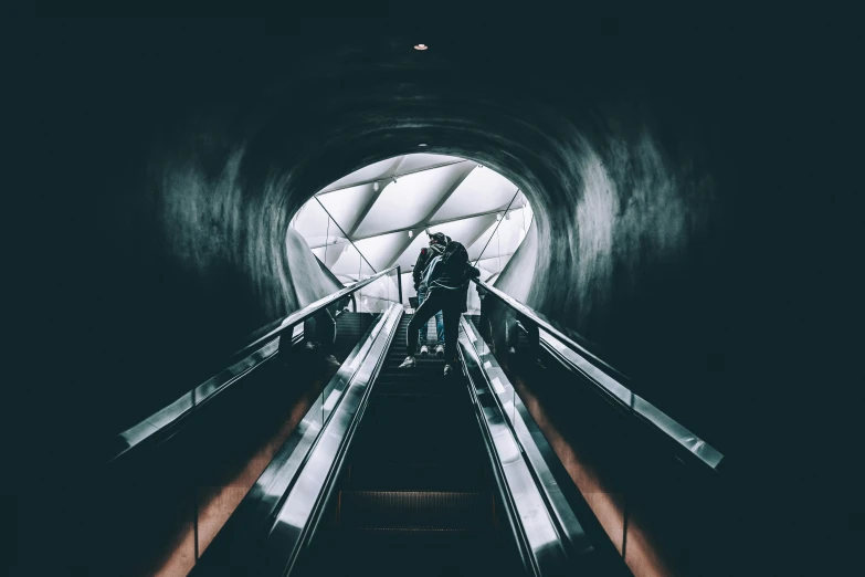 a person is standing on an escalator in a tunnel