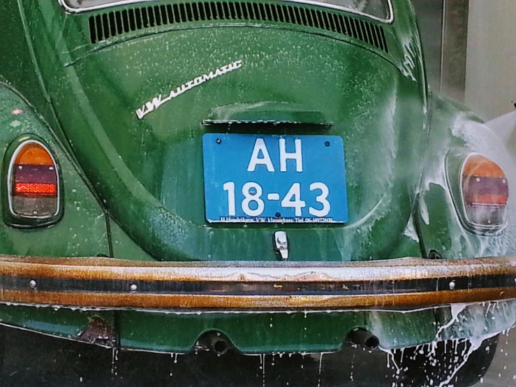 a green vw bug parked in a garage