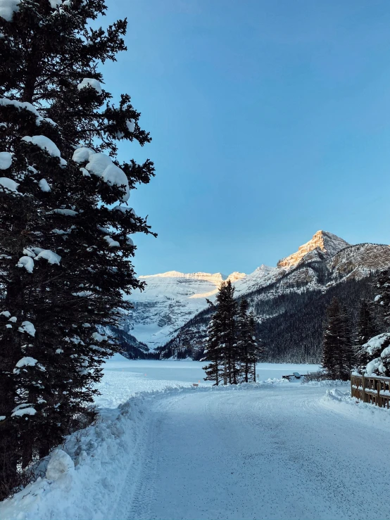 snow covered roadway in mountains during sunset on a winter day