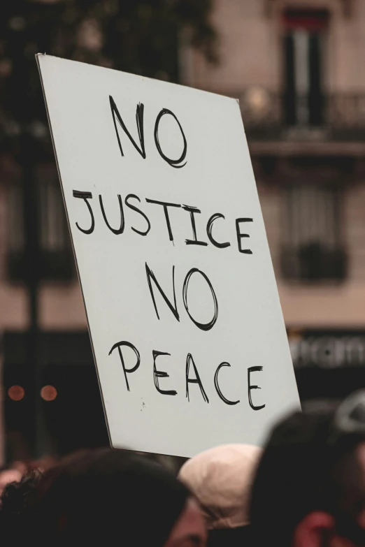 a sign that says no justice no peace in black lettering