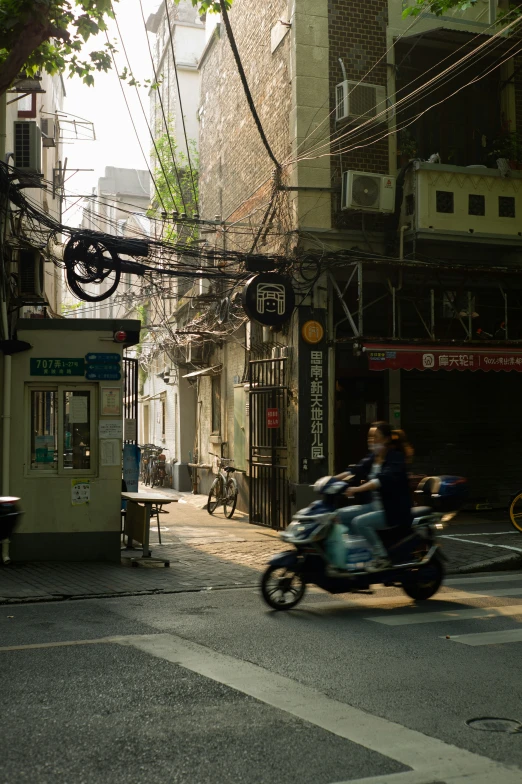 two people ride motorcycles down the street