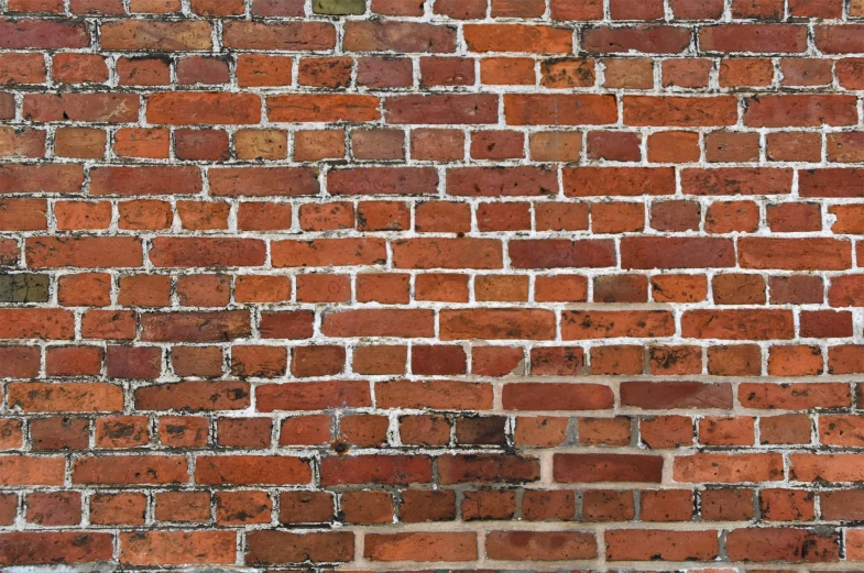 a close up view of the side of an old brick wall with white s