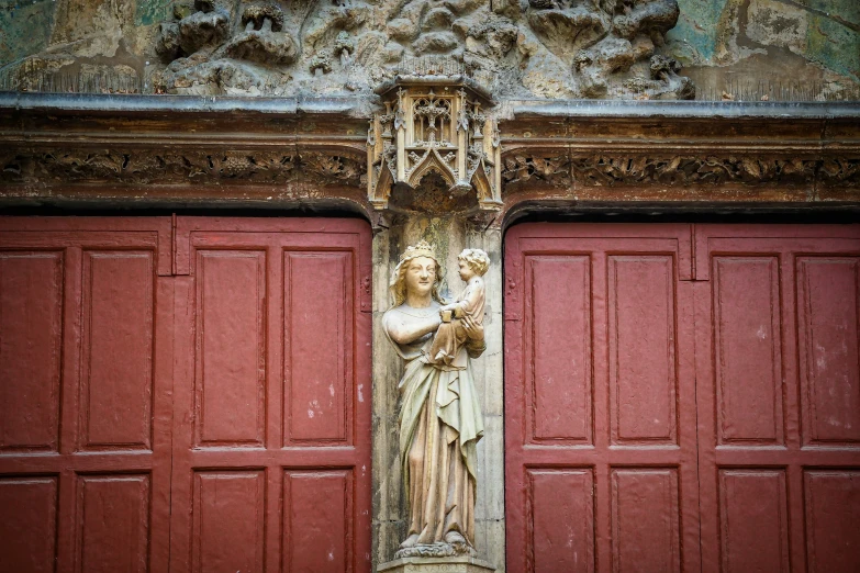 a statue is in front of two doors