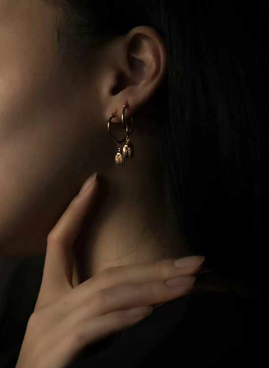 an image of a woman wearing two large gold hoop earrings