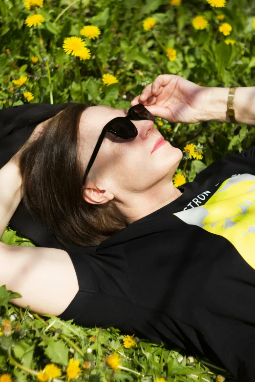 a woman laying in the grass with her eyes closed