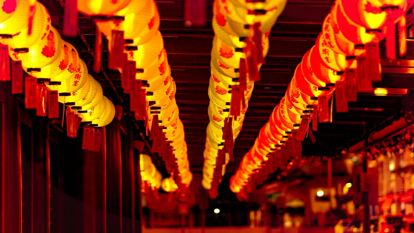 some lights are hanging from the ceiling near many red columns